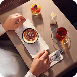 Business Class dessert service featuring tiramisu and warm tahini halva